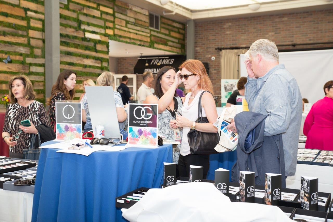 Person trying on Oliver Goldsmith sunglasses at Raise Your Glasses 2018 Event