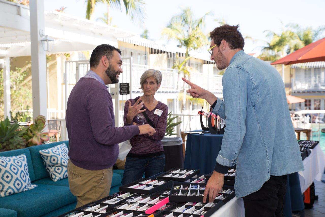 3 people chatting about eyewear selections at Raise Your Glasses 2018 Event