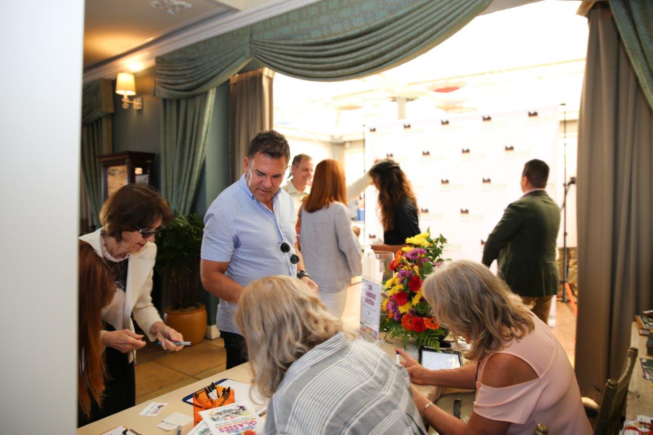 Guests signing in at reception table at Raise Your Glasses 2018 Event