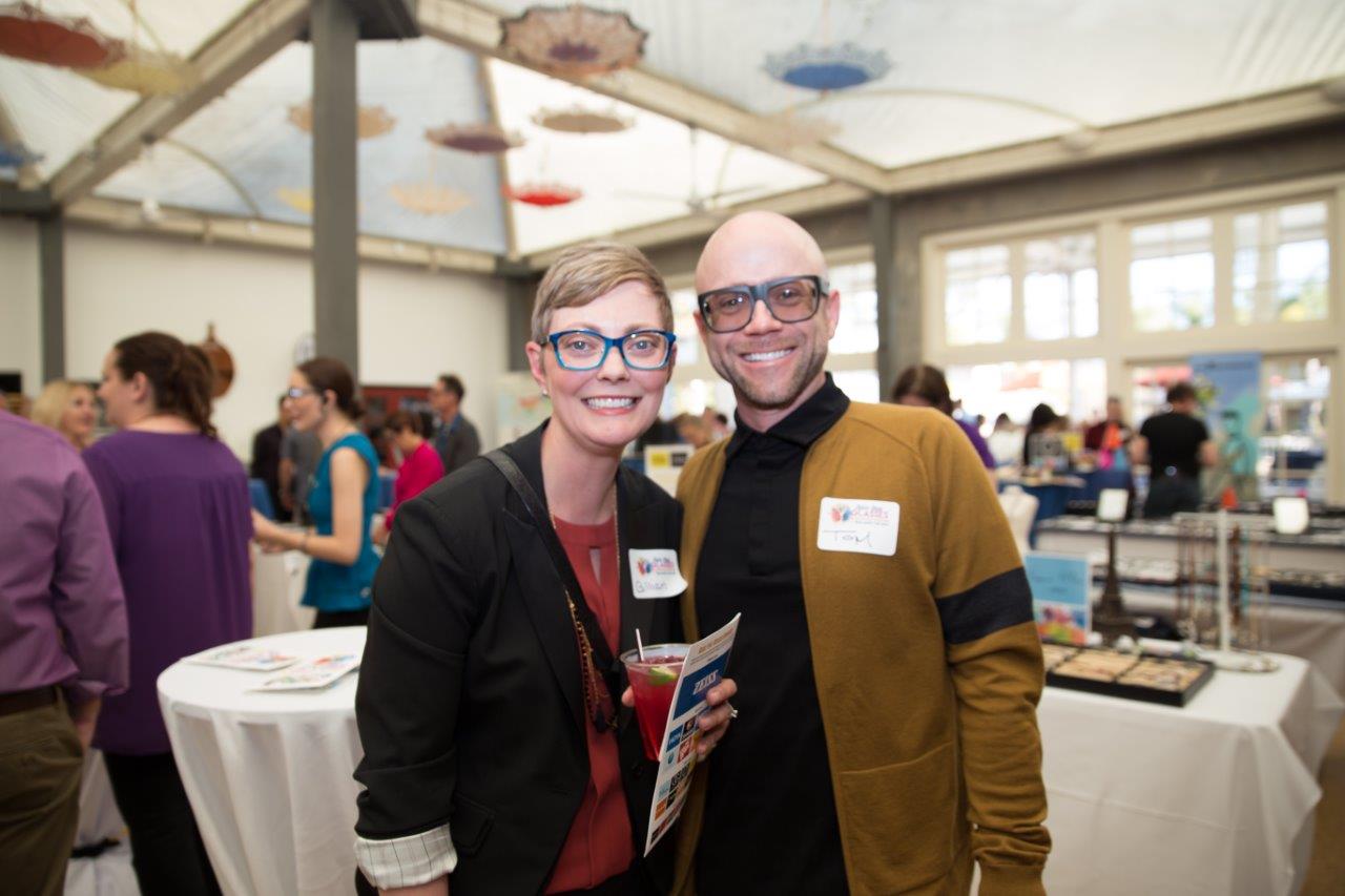 2 guests wearing colorful glasses at Raise Your Glasses 2018 Event