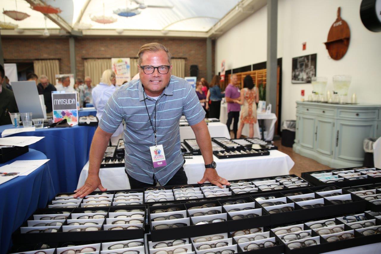 Vendor at tabletop with frames at Raise Your Glasses 2018 Event
