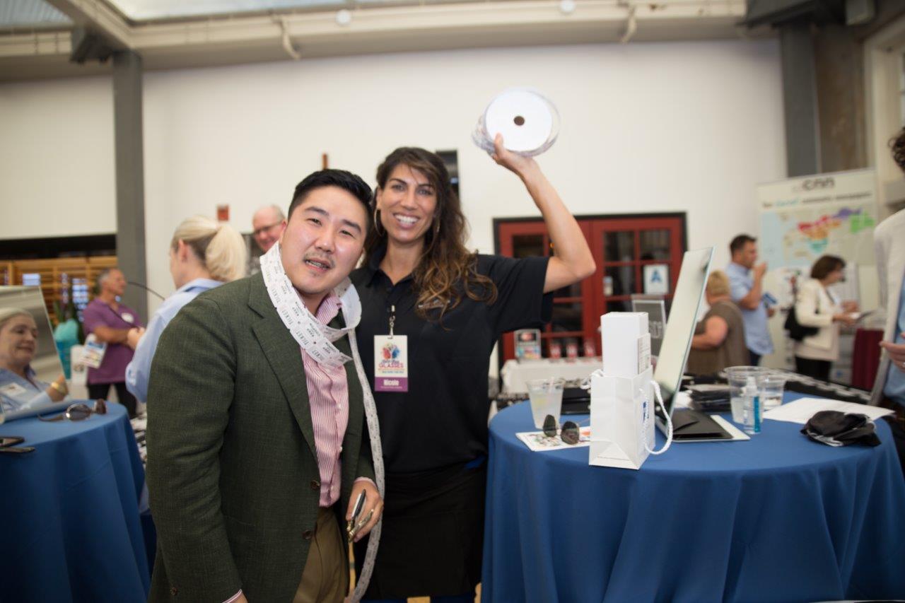 2 people posing with drawing tickets at Raise Your Glasses 2018 Event