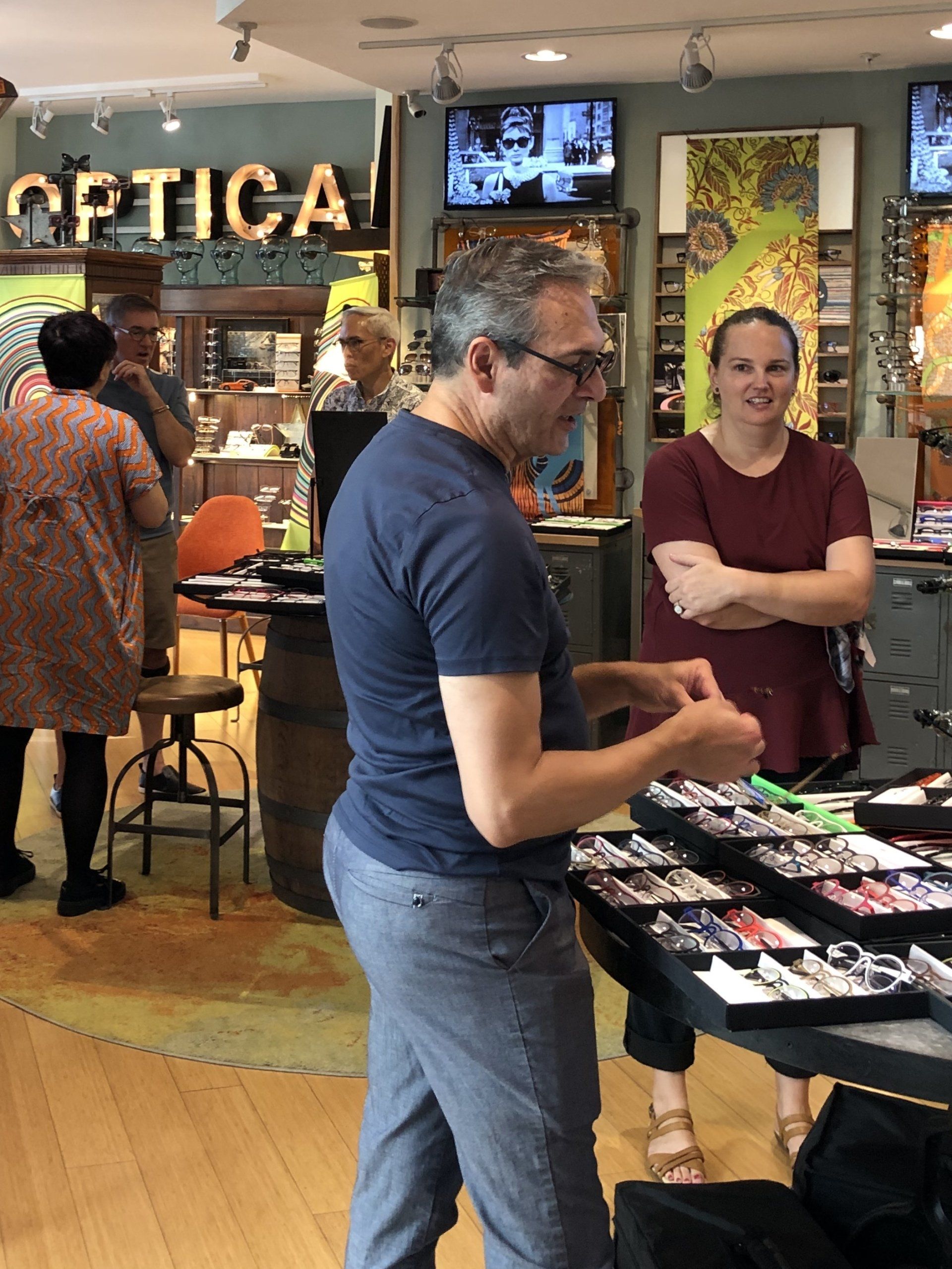 Two people looking at display cases of Theo frames at Theo Trunk Show Event