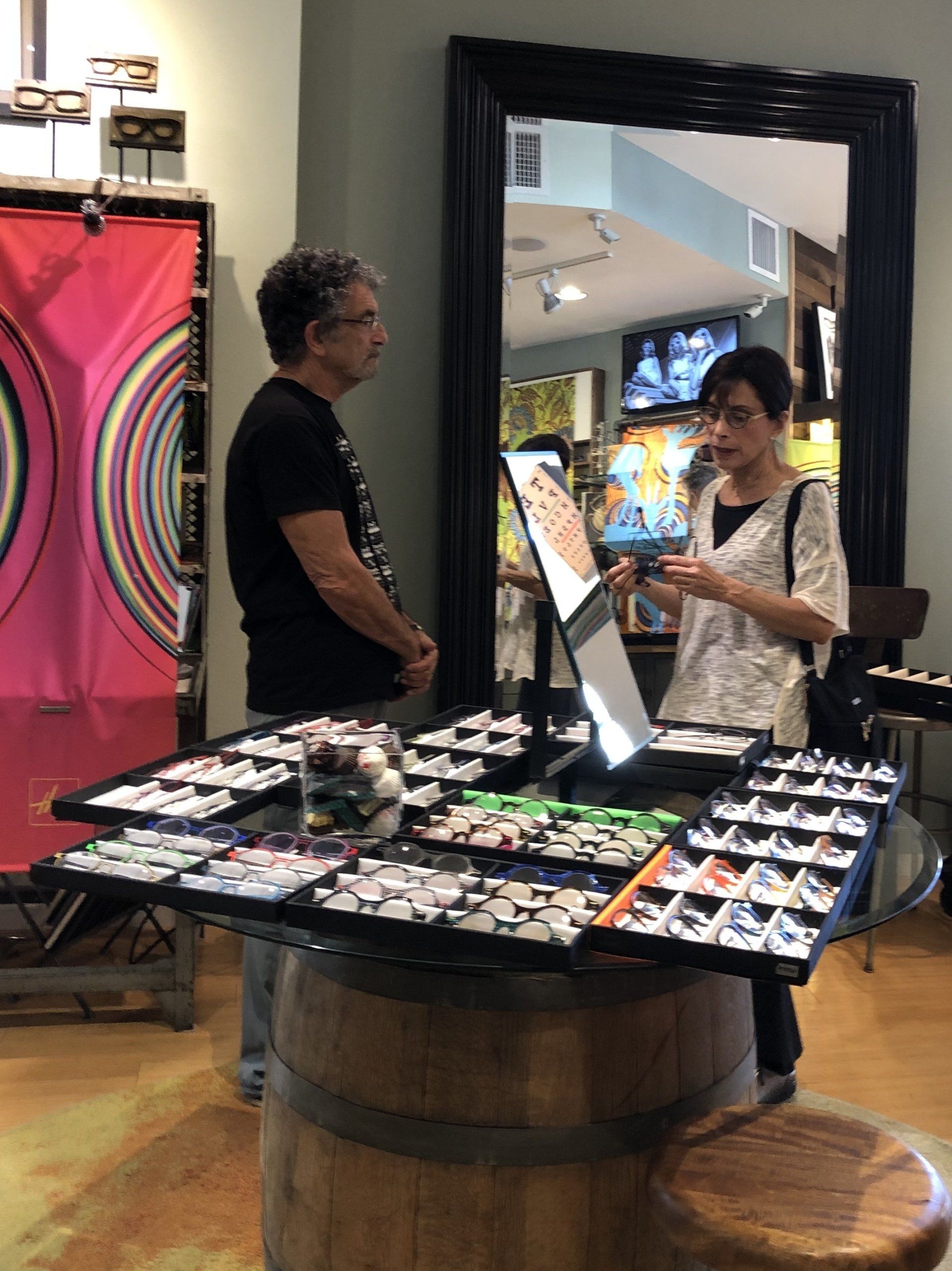 Two people standing at table with frames at Theo Trunk Show Event