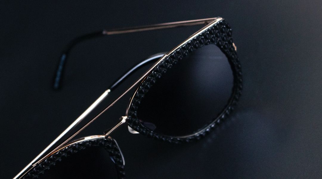 Pair of baclk and silver sunglass with patterned front.