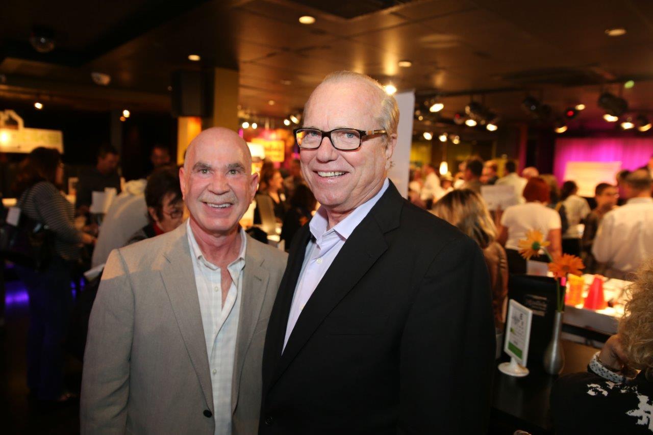 Two people smiling at Martinis Above Fourth at Raise Your Glasses event