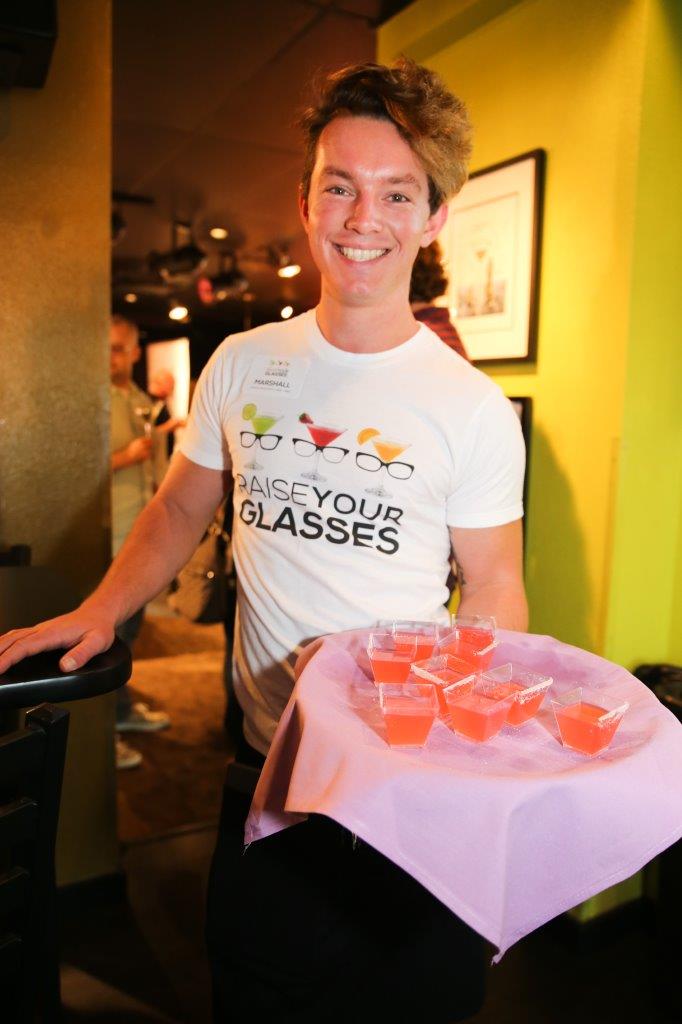 Server smiling while serving drinks at Raise Your Glasses event