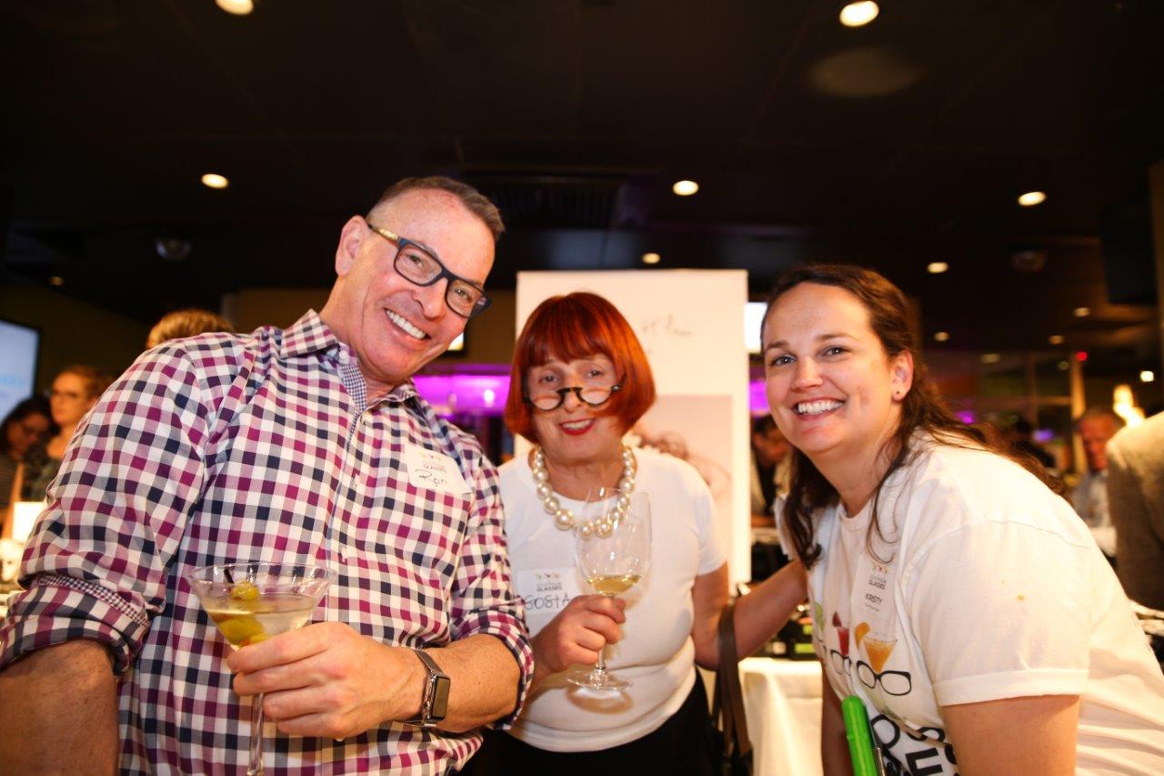 3 guests standing inside Martinis Above Fourth at Raise Your Glasses event