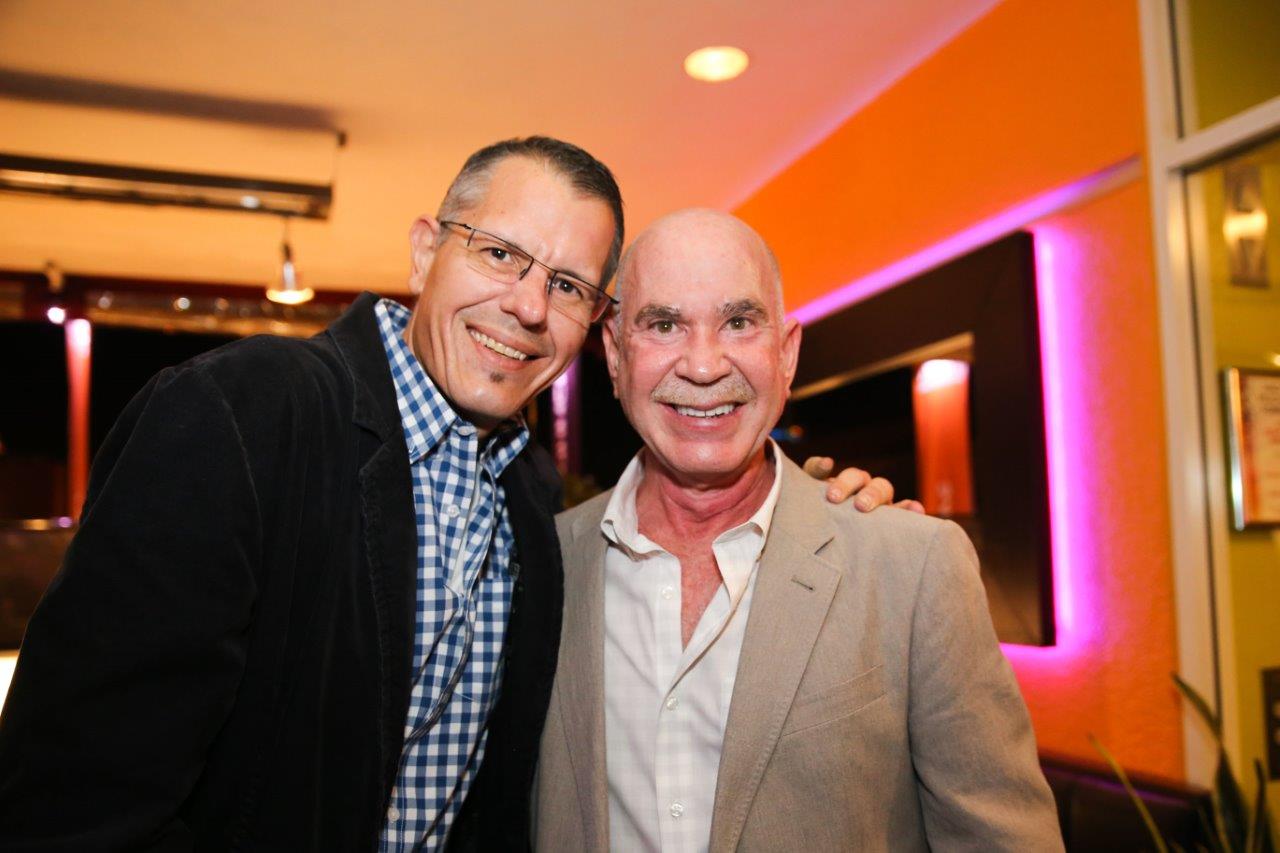 Two men smiling at Raise Your Glasses event