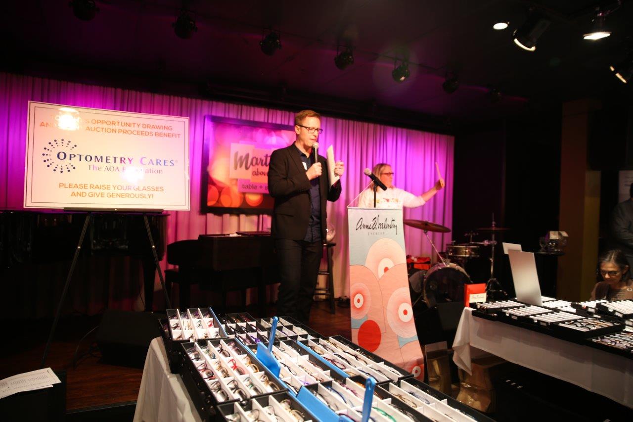 Person standing on stage inside Martinis Above Fourth at Raise Your Glasses event