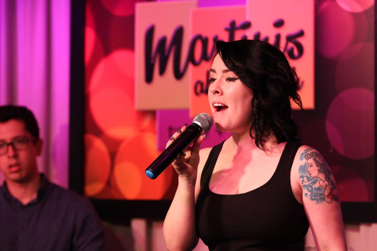 Young woman singing at Raise Your Glasses event