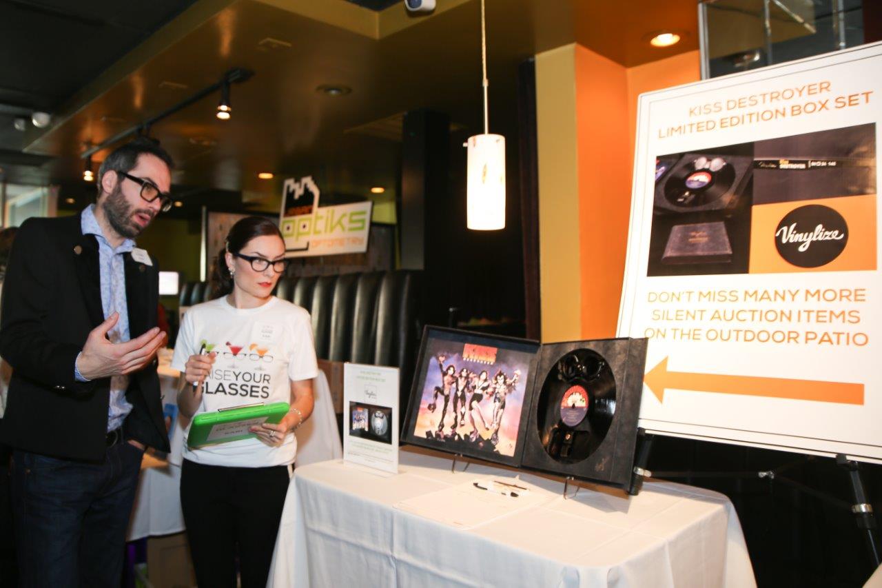 Attendees looking at vendor table at Raise Your Glasses event