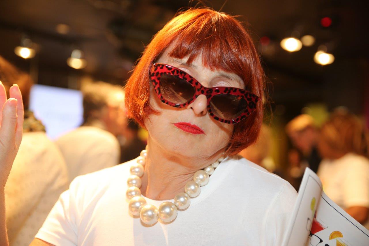 Attendee in sunglasses posing at Raise Your Glasses event