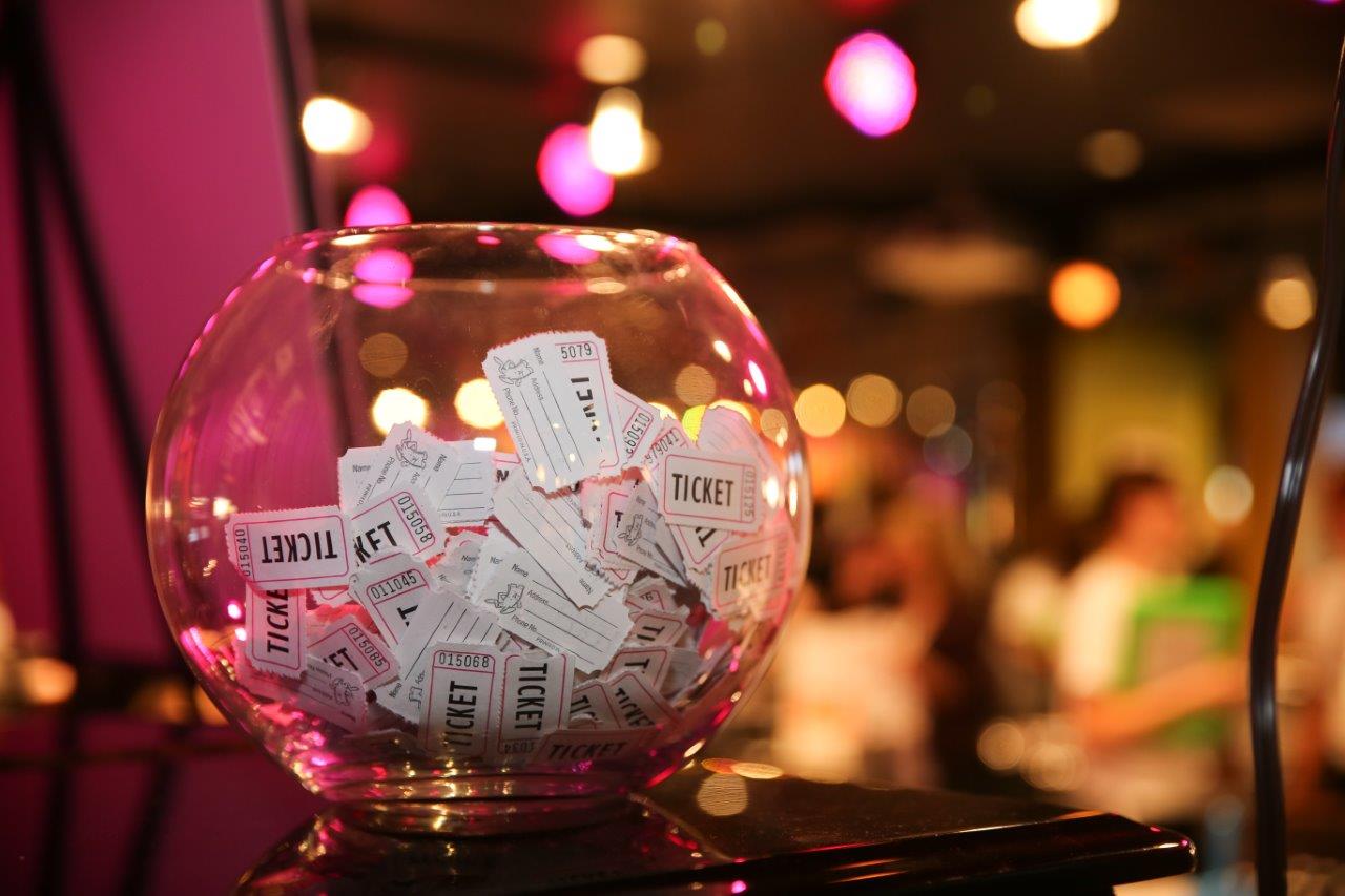 Glass jar filled with tickets at Raise Your Glasses event