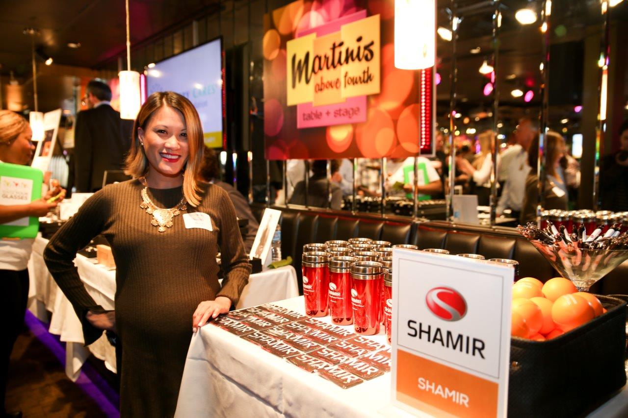 Vendor standing next to a table at Raise Your Glasses event