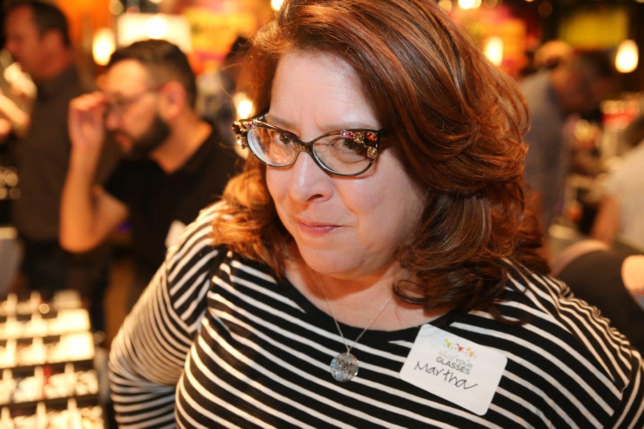 Woman in glasses smiling at Raise Your Glasses event