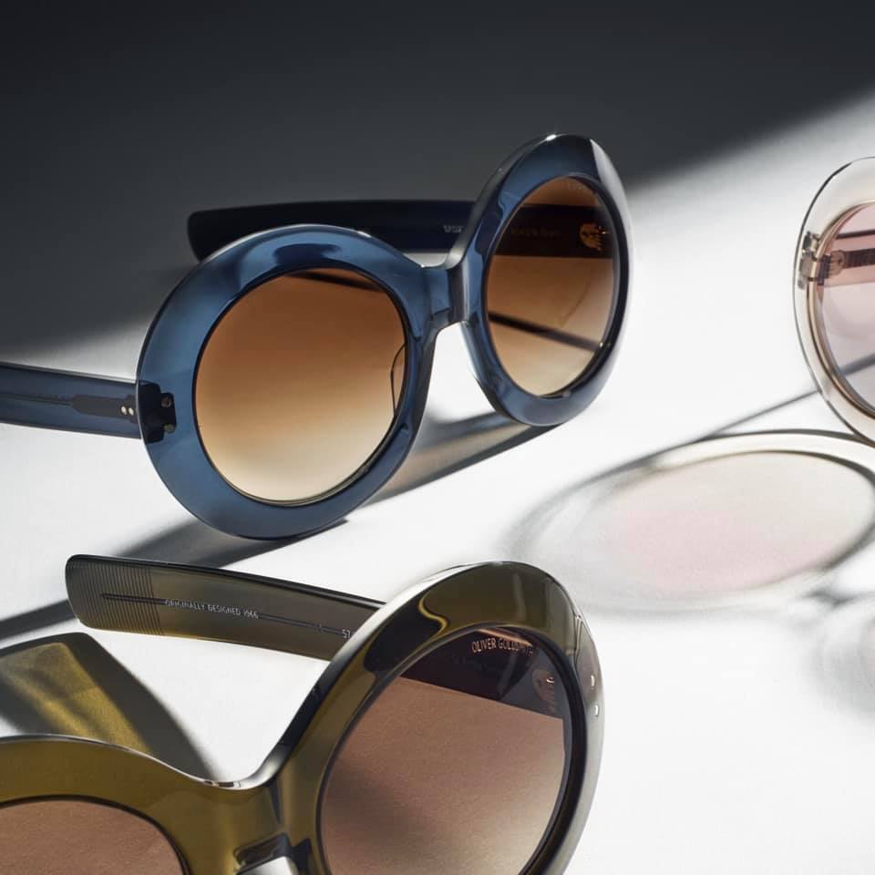 Three Oliver Goldsmith round-shaped sunglasses in blue, green and clear colors