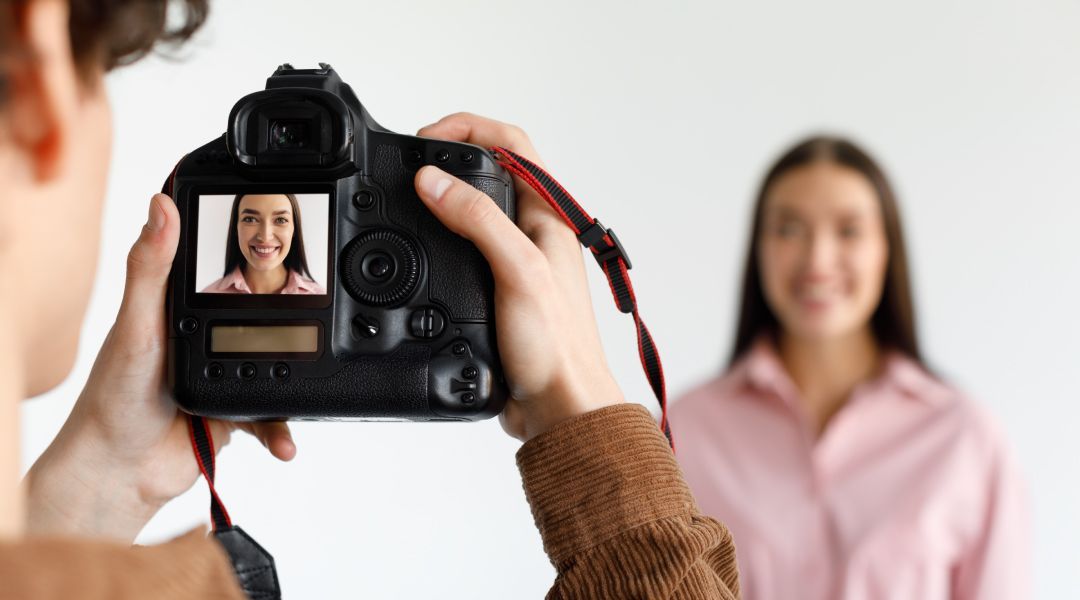 A man is taking a picture of a woman's face with a camera