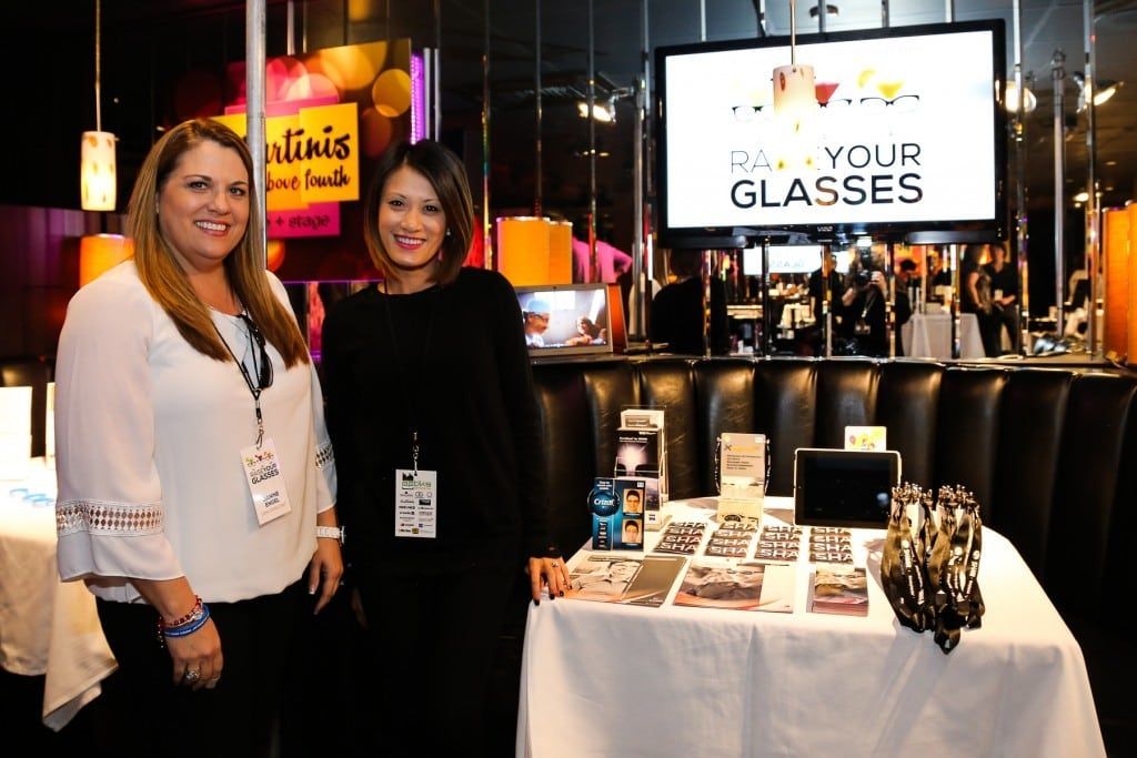 Two people standing at vendor table at 2015 Raise Your Glasses event