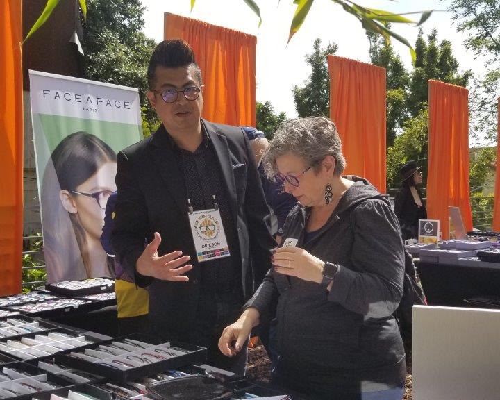Vendor and guest looking at frameline at Urban Optiks Optometry 2019 Raise Your Glasses Event