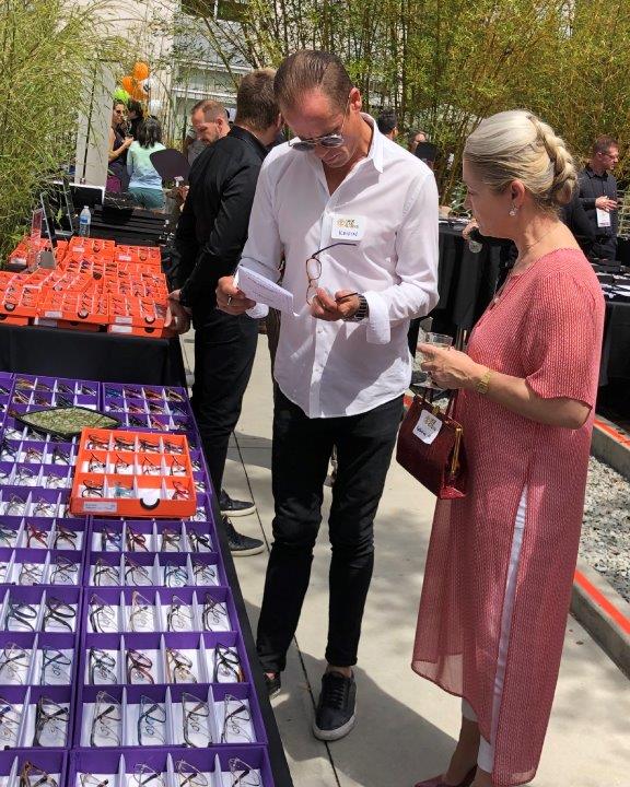2 people admiring displays of eyeglass framelines at Raise Your Glasses 2019 Event