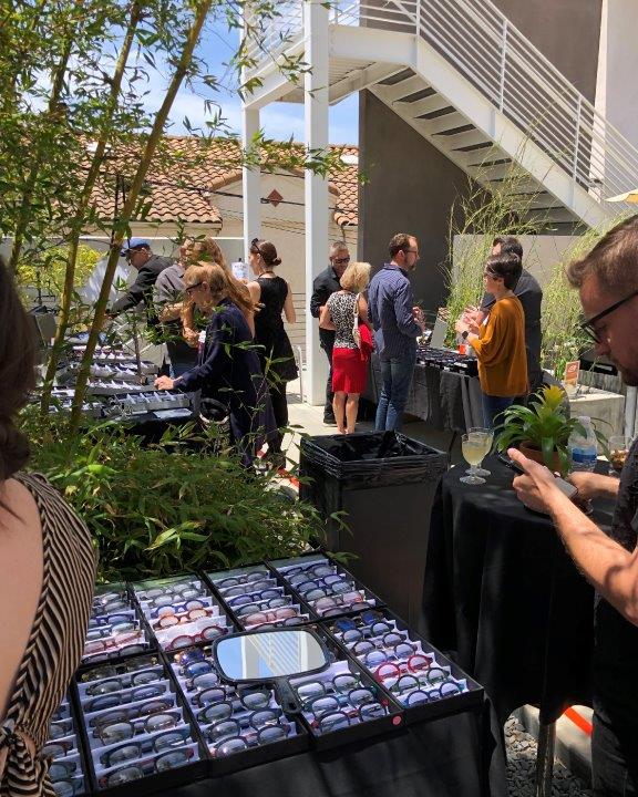 Displays of eyeglass framelines and people in background at Raise Your Glasses 2019 Event