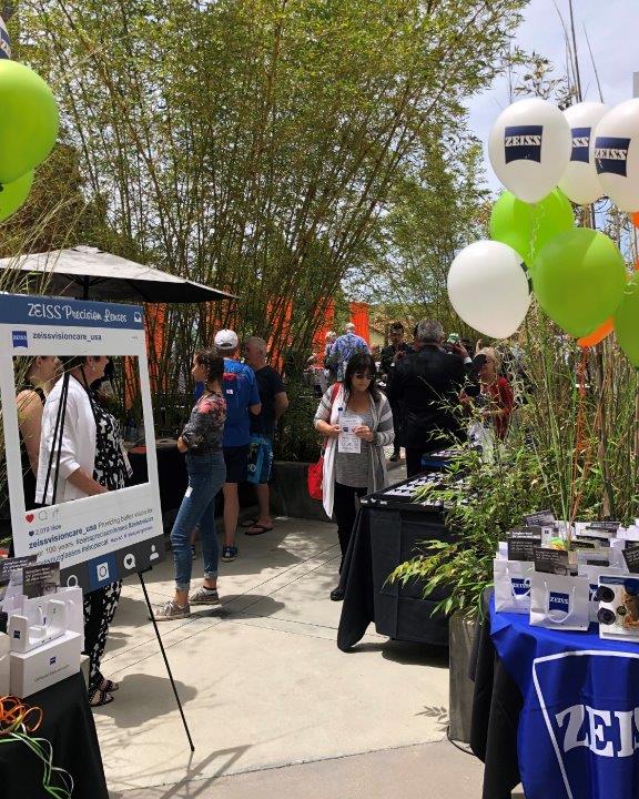 Table with balloons and info and people in background at Raise Your Glasses 2019 Event