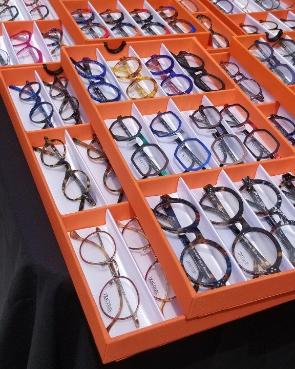 Many orange display boxes of assorted eyeglasses at 2019 Raise Your Glasses Event