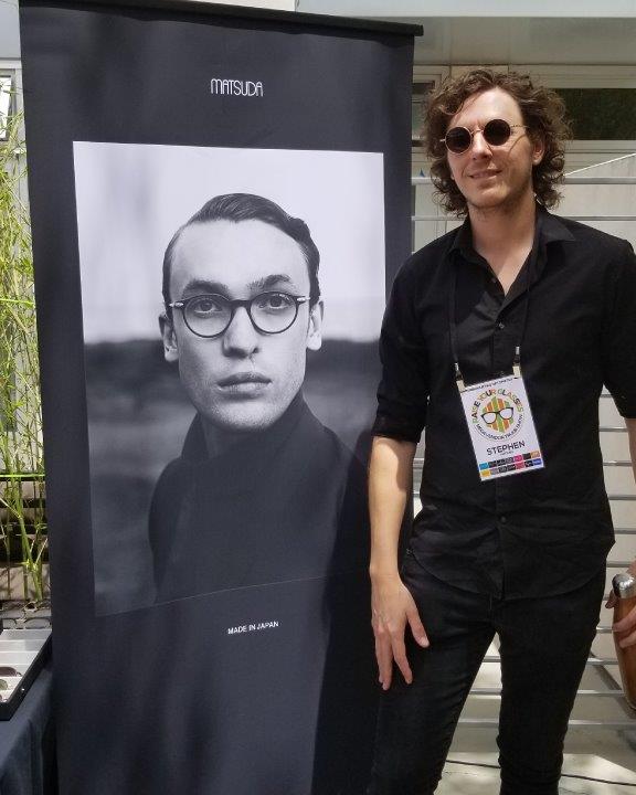 Vendor posing in front of large Matsuda banner at 2019 Raise Your Glasses Event