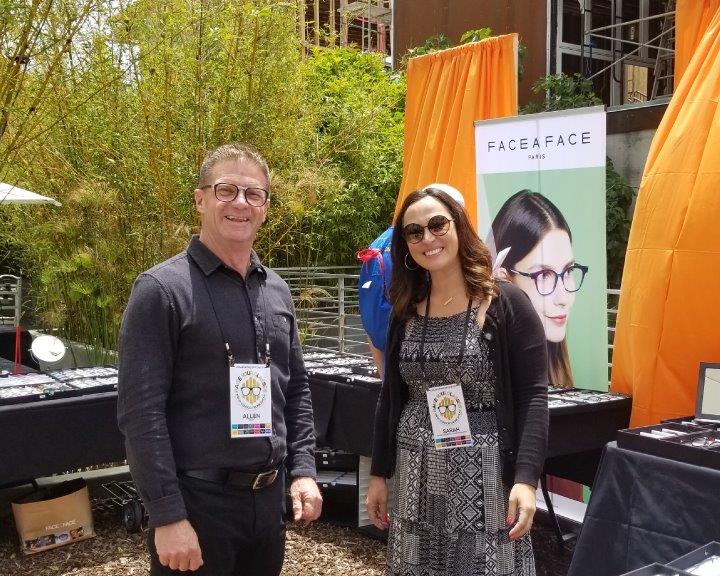 2 vendors smiling in front of Face a Face banner at 2019 Raise Your Glasses Event