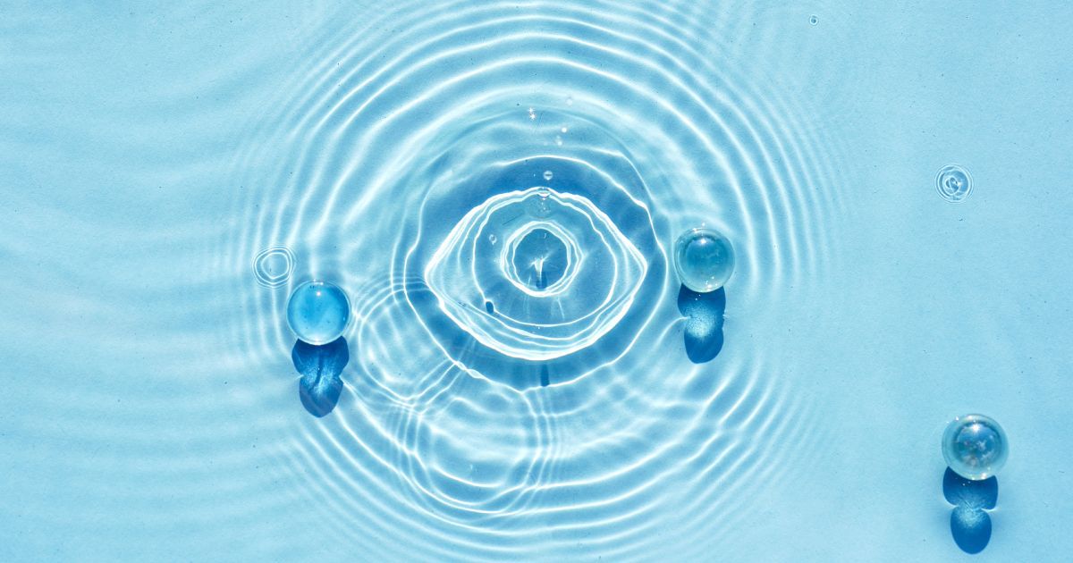 A close up of water waves in a pool causing a reflection of an eyeball.