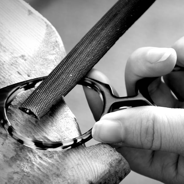 Close up of a frame being hand finished with file