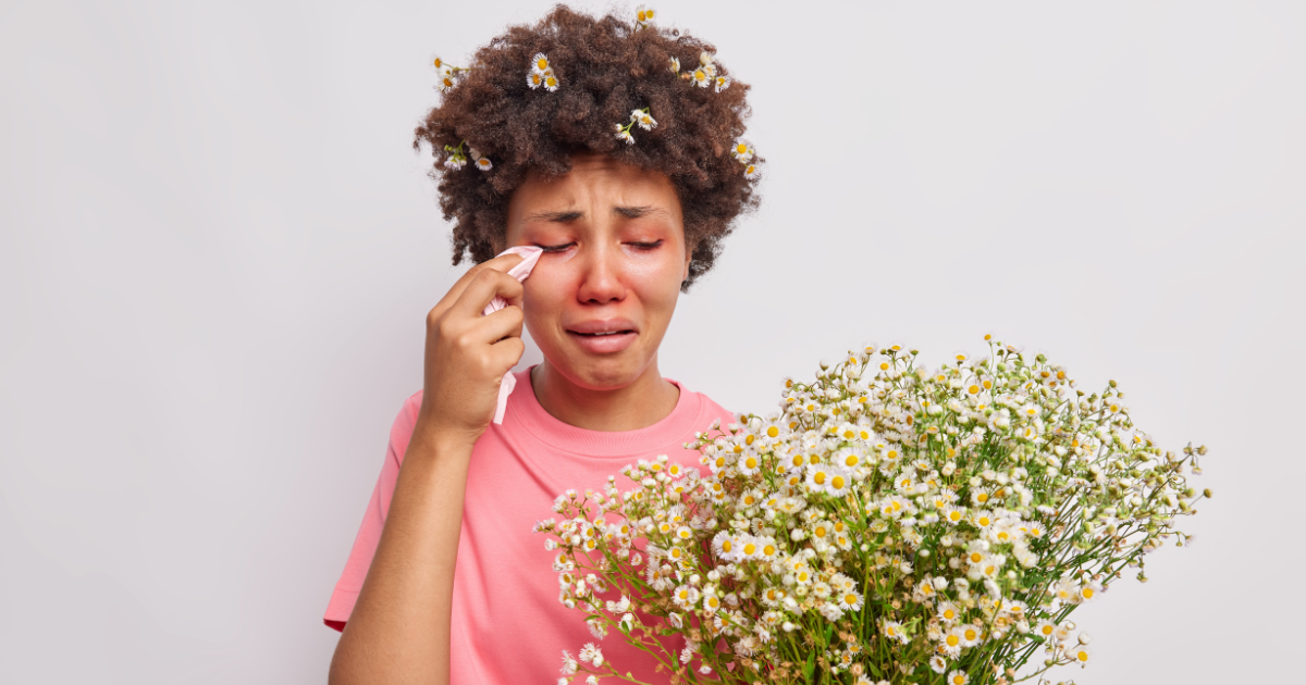 A woman is crying while holding a bouquet of flowers.