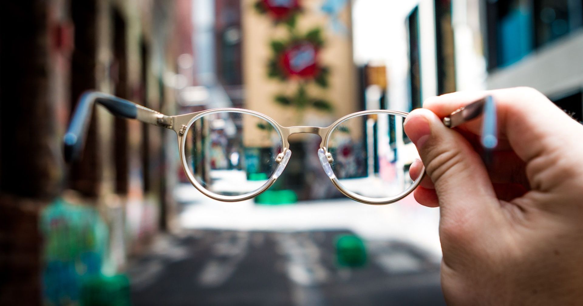 a person holding a pair of glasses in their hand