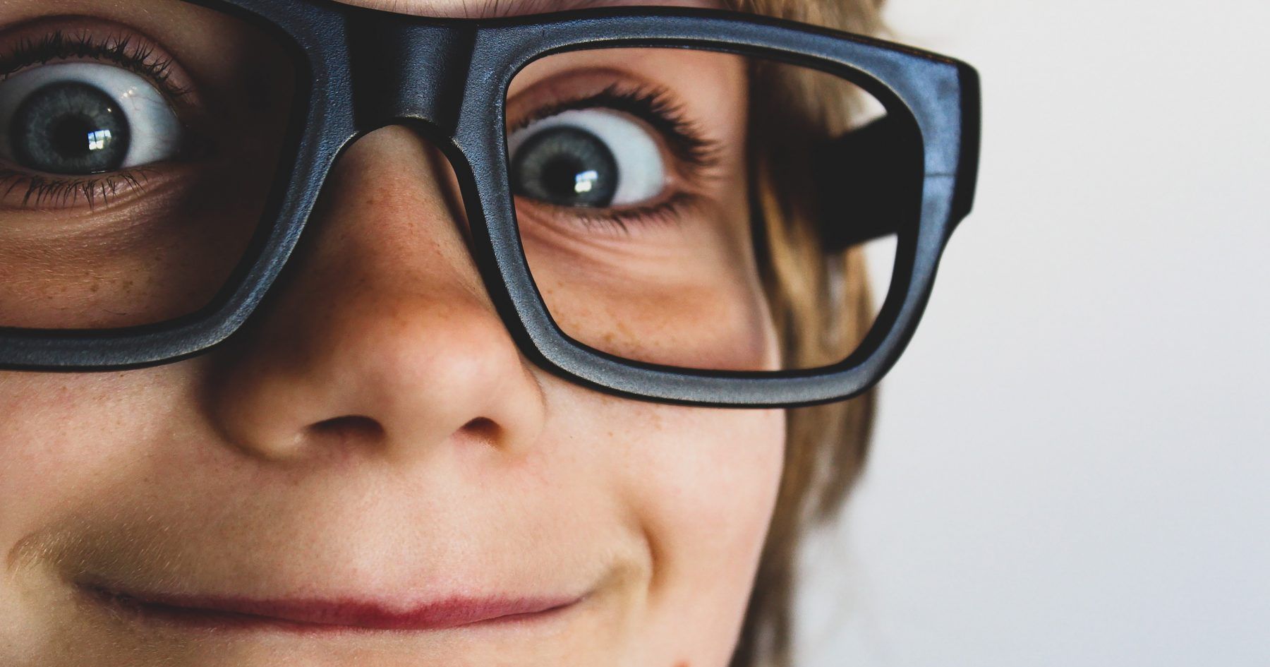 Close up of smiling a child wearing black eyeglass frames
