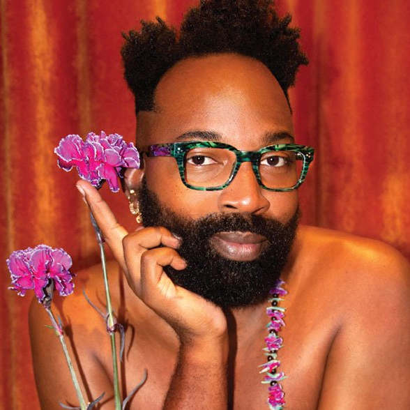 Man with a multi-color la Eyeworks frame holding pink carnations