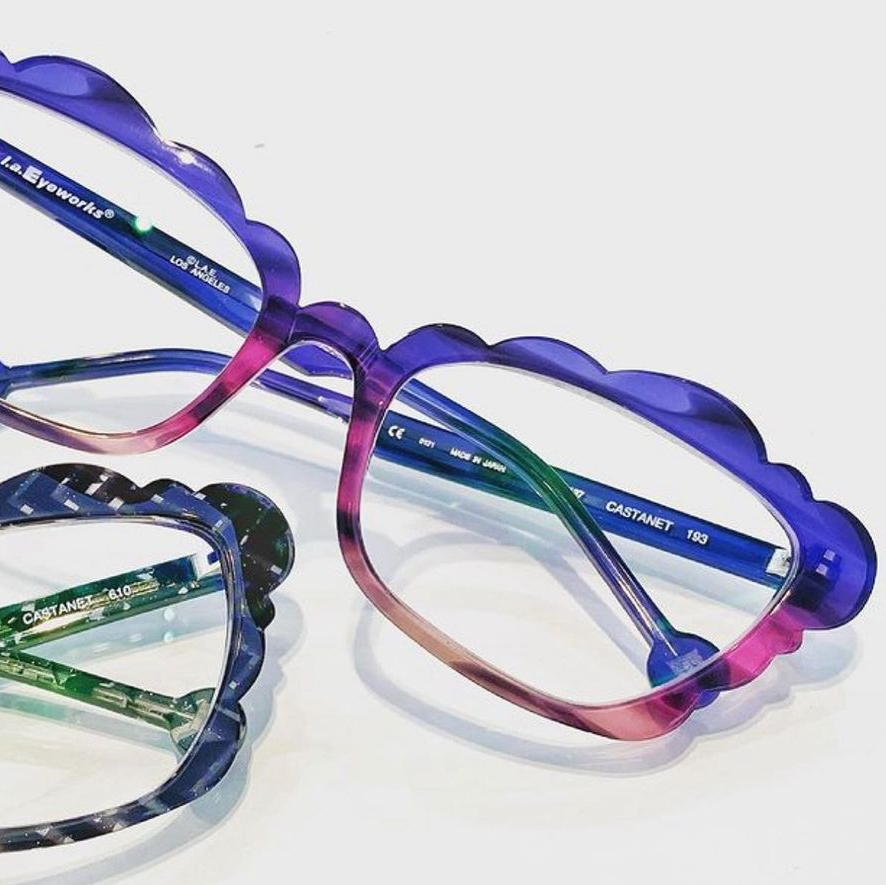 Two la Eyeworks frames with scalloped edges in pink, purple, and greens