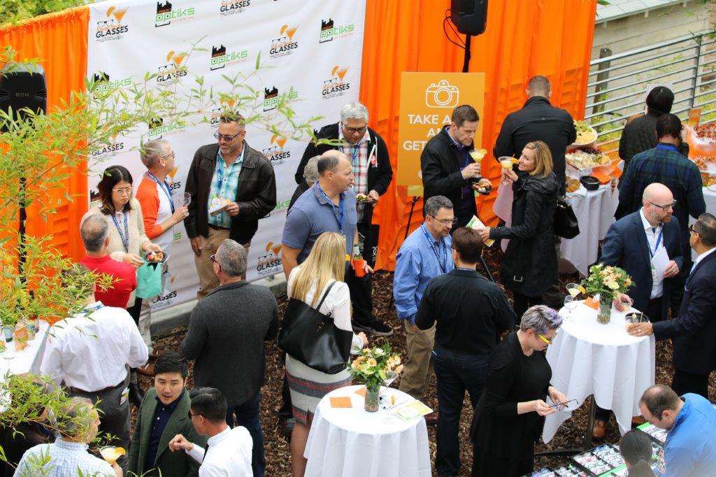 View from above of vendor and guests in front of logo banners at Raise Your Glasses 2017 Event