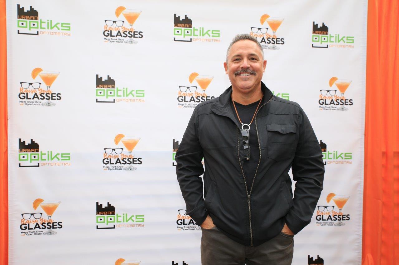 Person posing in front of banner at Raise Your Glasses 2017 Event