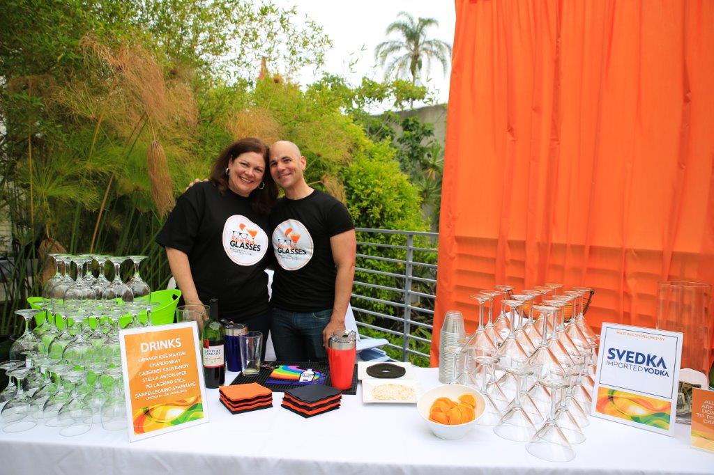 Two people standing people drinks table at Raise Your Glasses 2017 Event