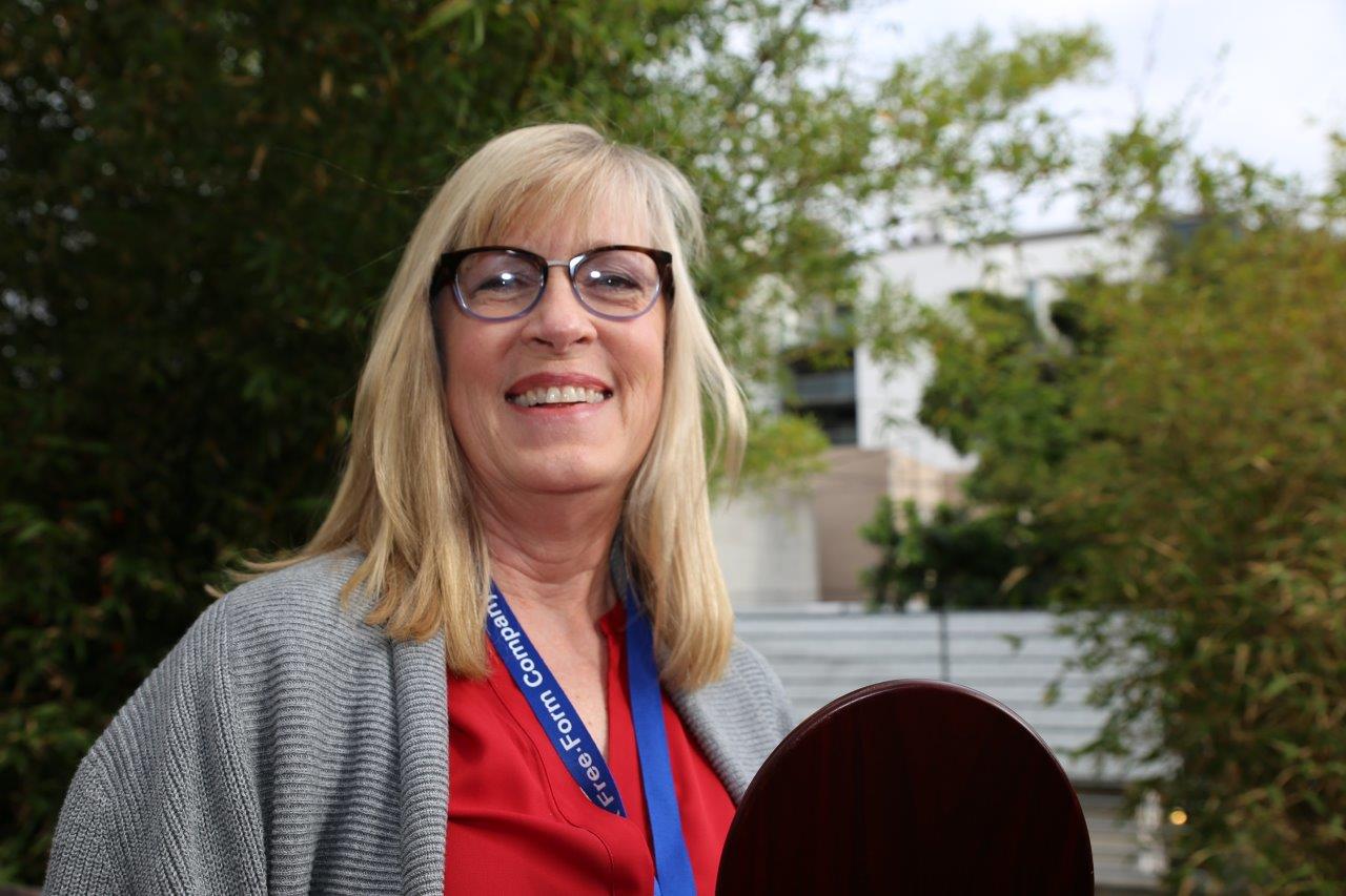 Person wearing glasses and smiling at Raise Your Glasses 2017 Event