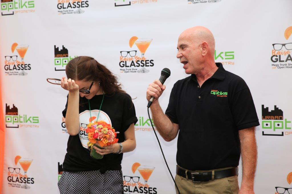 Person laughing and man holding microphone at Raise Your Glasses 2017 event