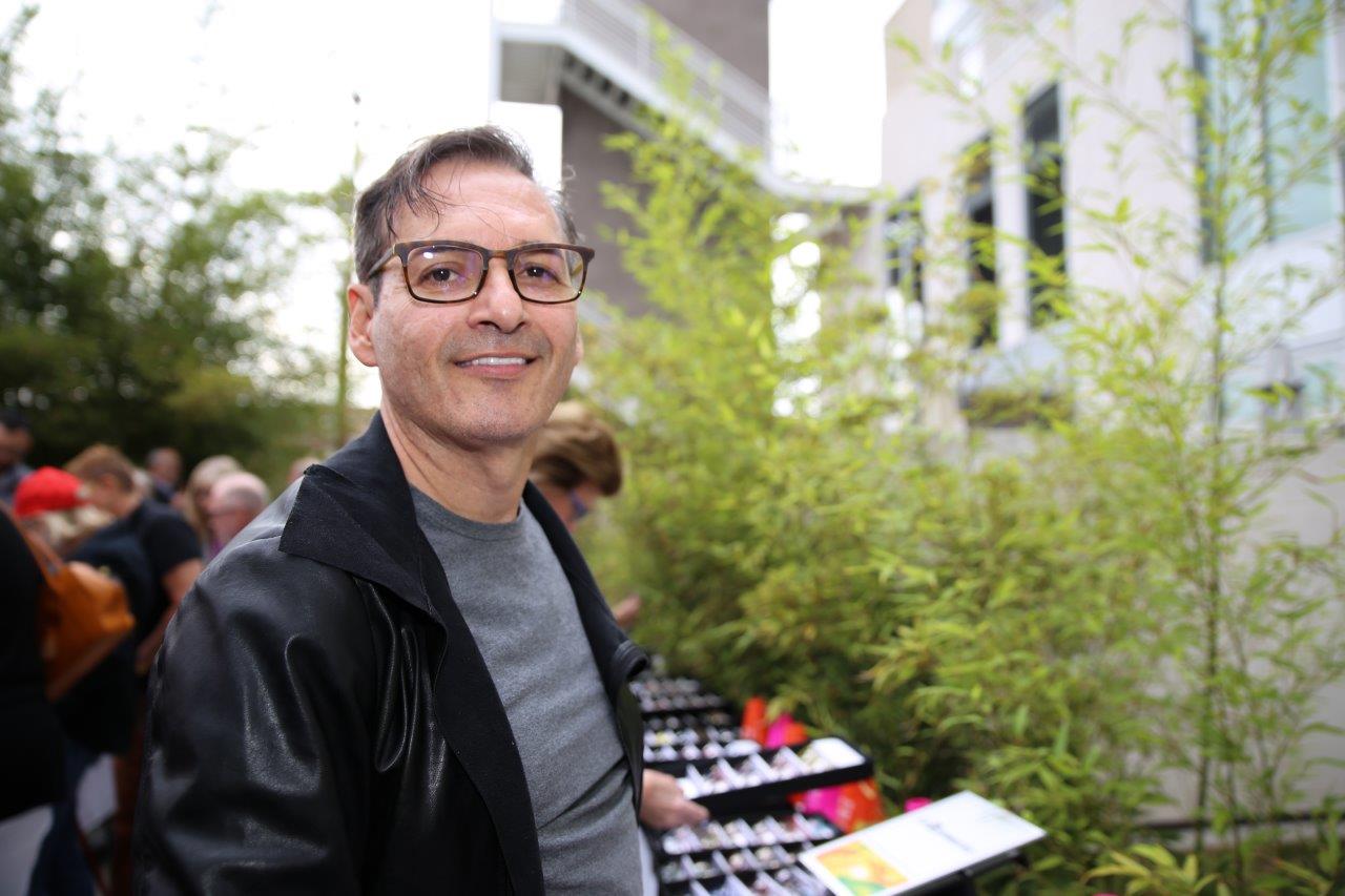 Person in black jacket trying on glasses at Raise Your Glasses 2017
