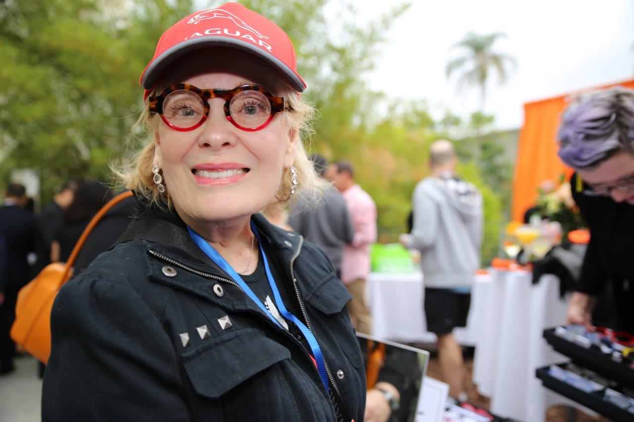 Person wearing a cap and modeling colorful glasses at Raise Your Glasses 2017