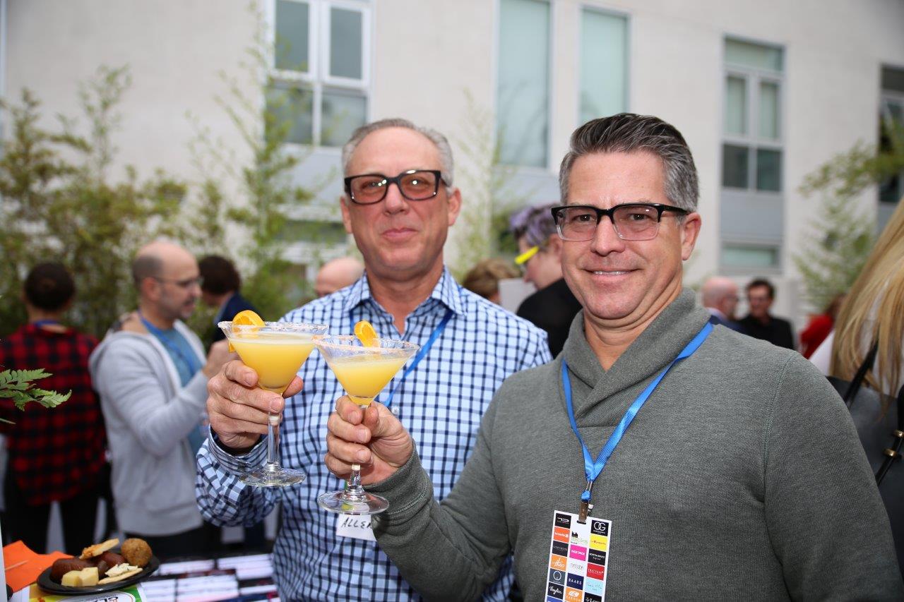 2 people raising martini glasses at Raise Your Glasses 2017 Event