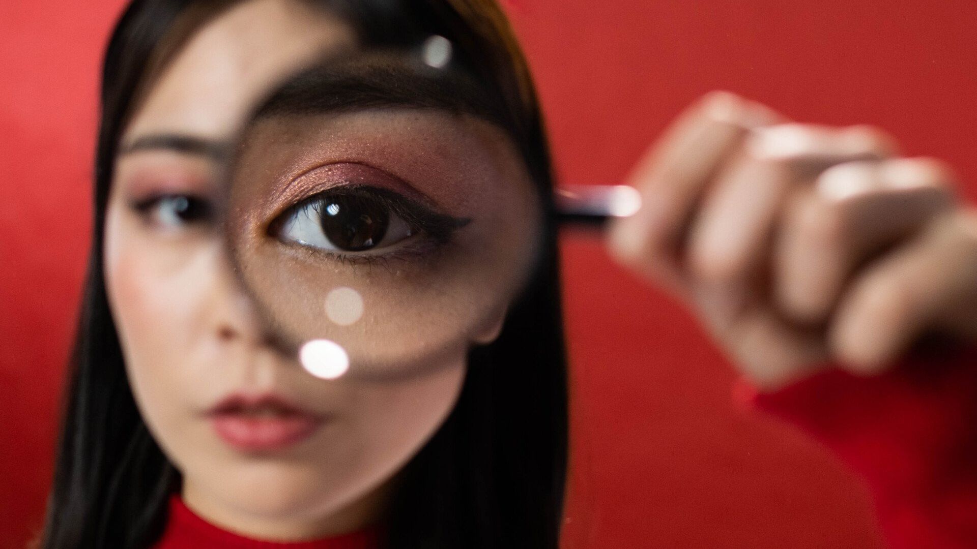 Person holding magnifying glass up to their eye