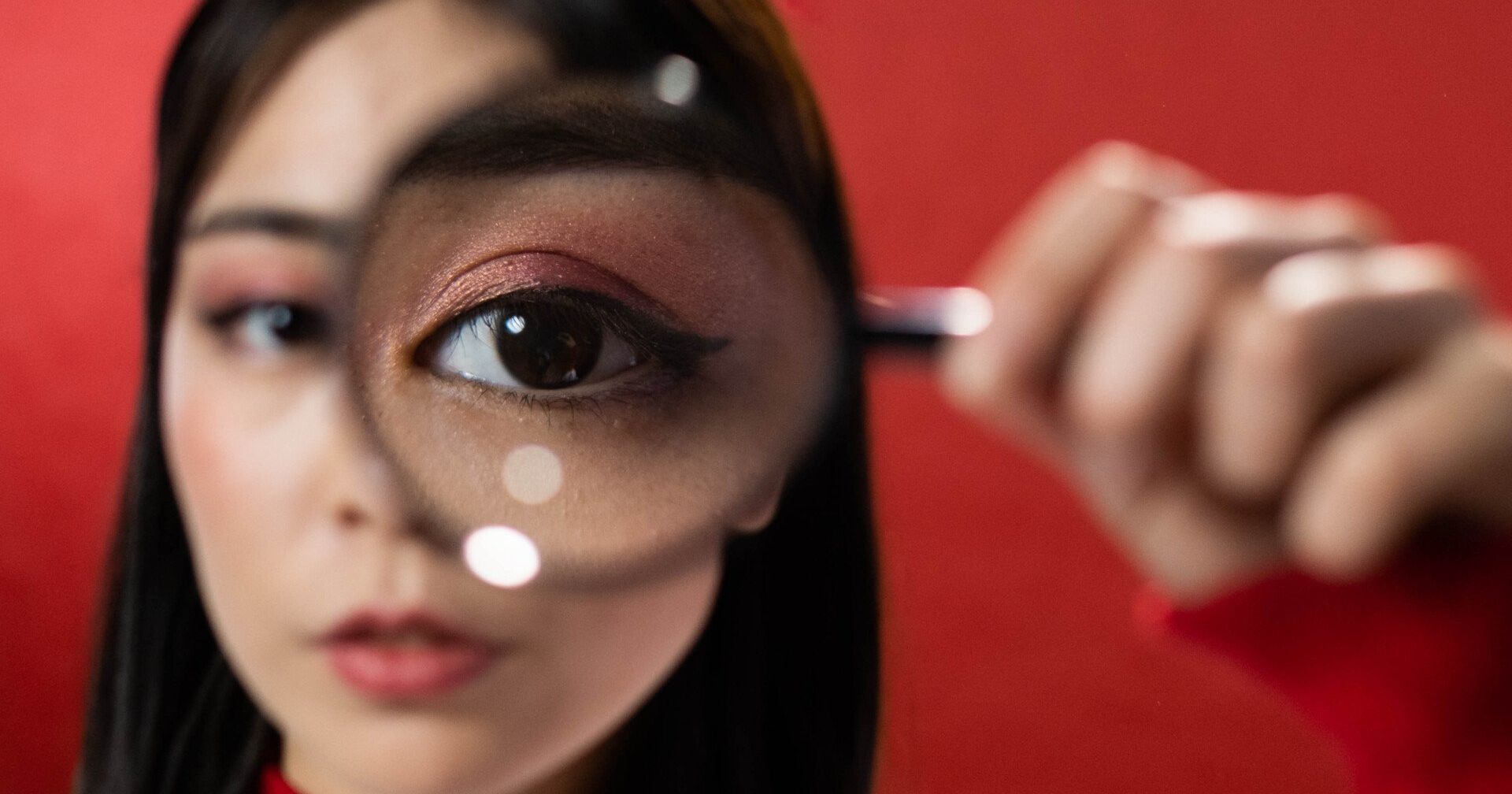Person holding magnifying glass up to their eye