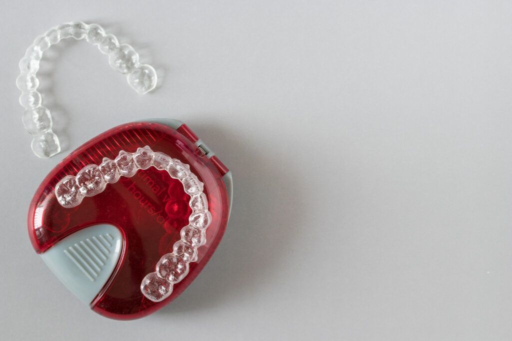 A red case with clear braces in it on a white surface.