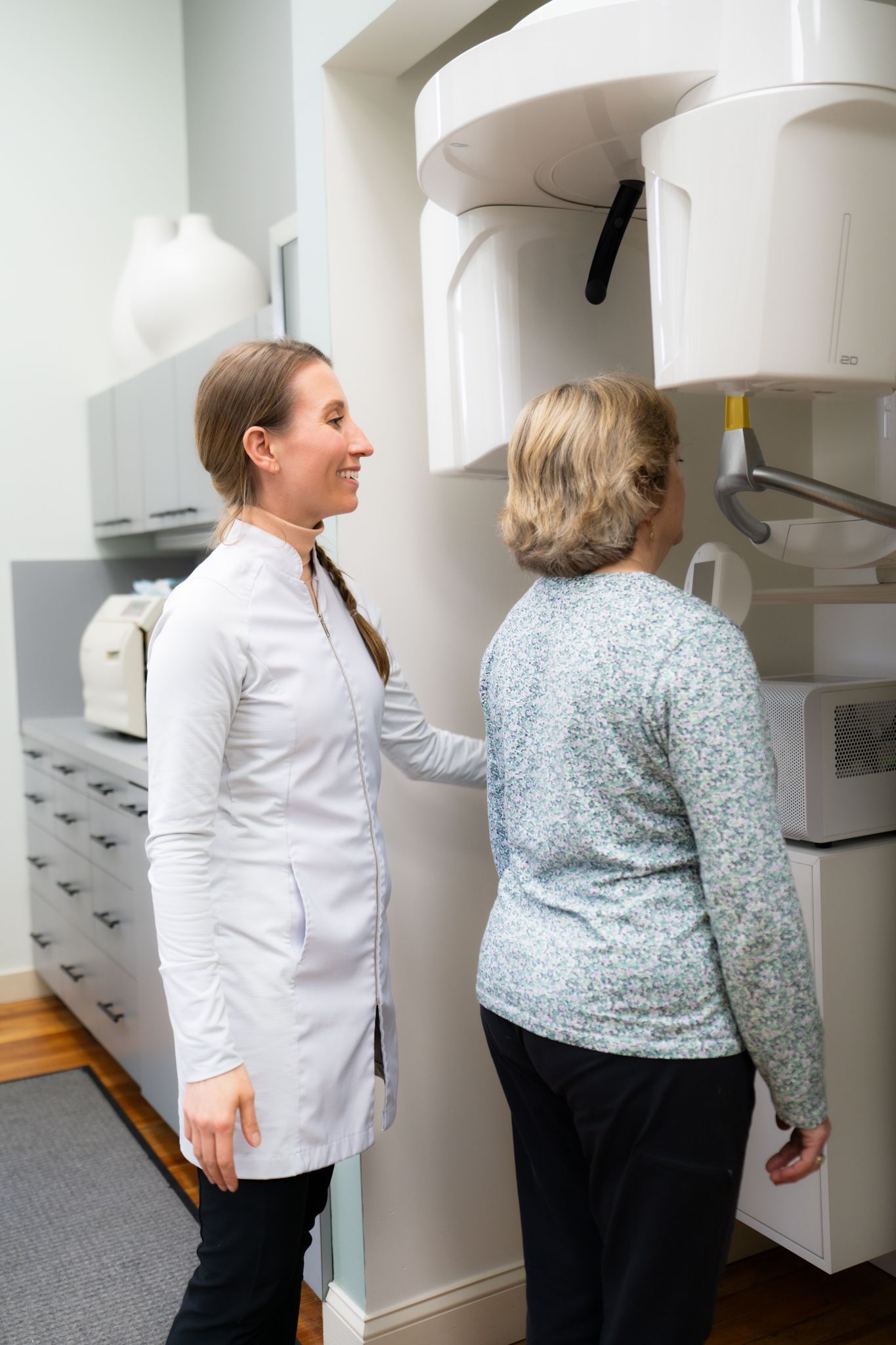 A dentist is talking to a patient in a dental office.