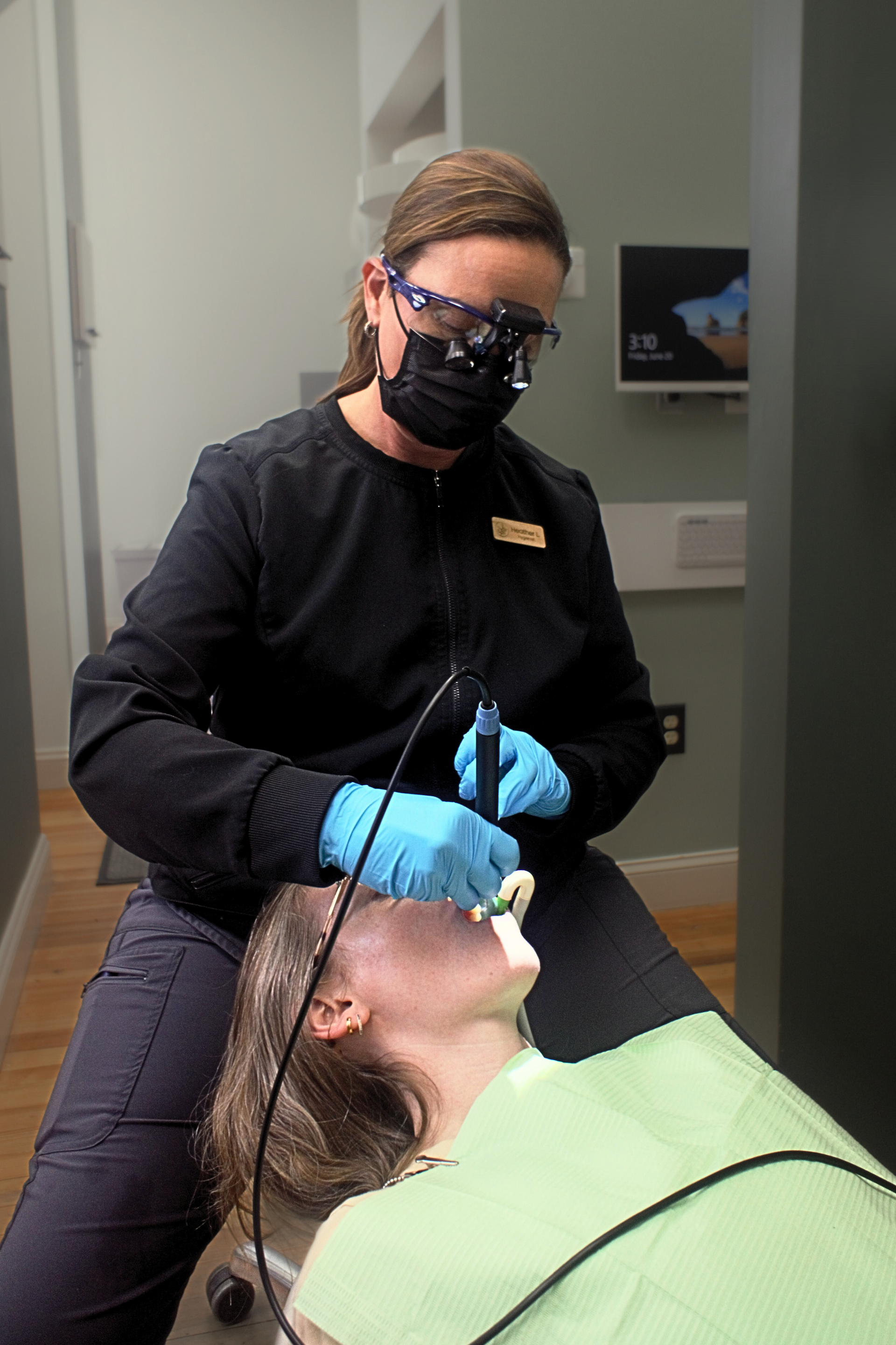 A woman is brushing her teeth in front of a mirror